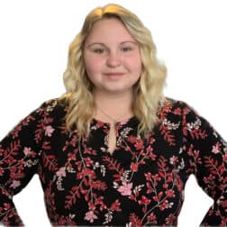 W&J senior Courtney McIntyre stands with her hands on her hips in front of a bright white backdrop.