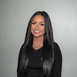 W&J senior Kristine Horissian smiles in front of a gray backdrop.