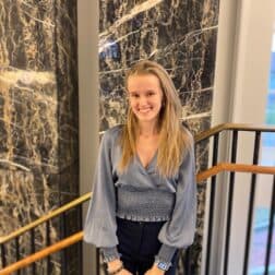 W&J senior Vanesa Hyde poses in front of a marble wall and smiles.