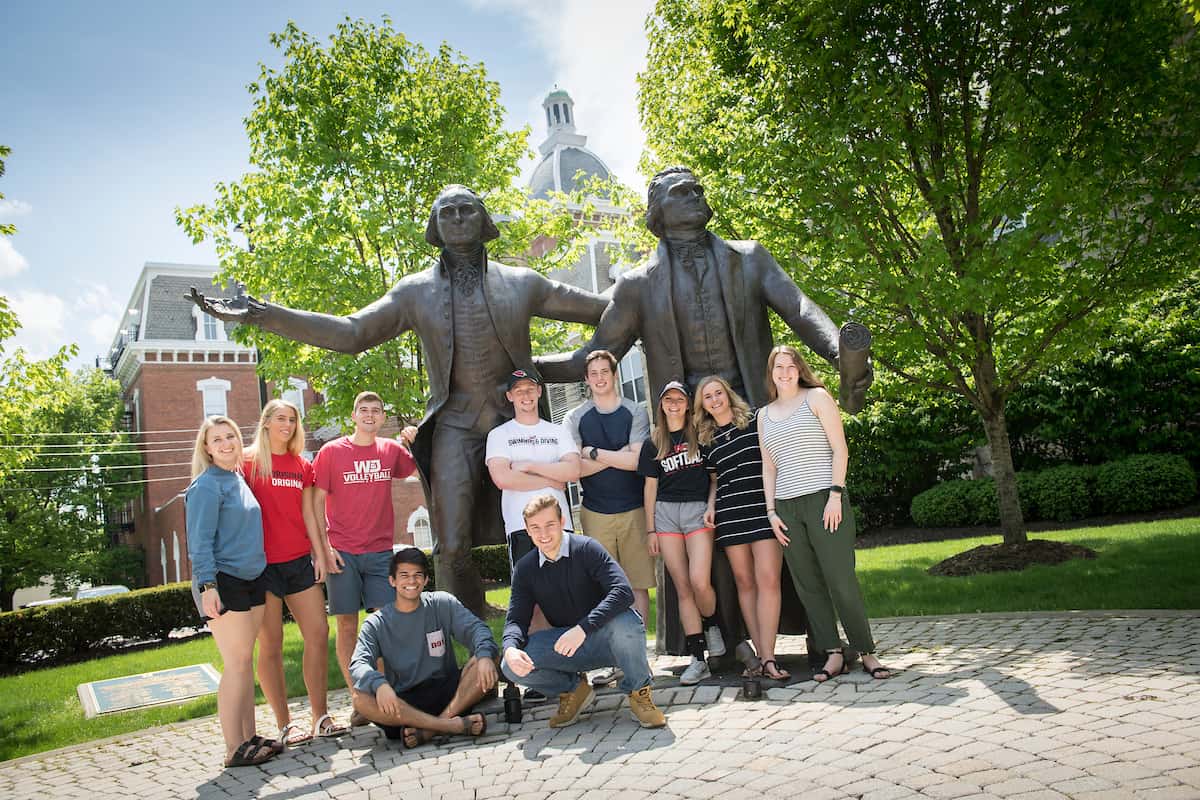 Photo of students standing in front of W&J's statues of George Washington and Thomas Jefferson.