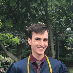 W&J senior Bryton Altenbach smiles in front of greenery.